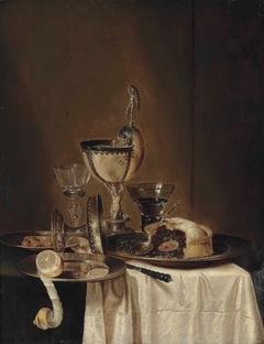 Still life of blackberry pie, pewter platter, roemer, tazza, lemon, olives and a nautilus cup by Willem Claesz Heda