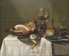 Still life with ham, lemon, roemer, glass flute, wine glass, olives, tazza, bread and knife by Willem Claesz Heda