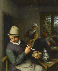 A tavern interior with a peasant smoking a pipe and figures playing cards by Anonymous